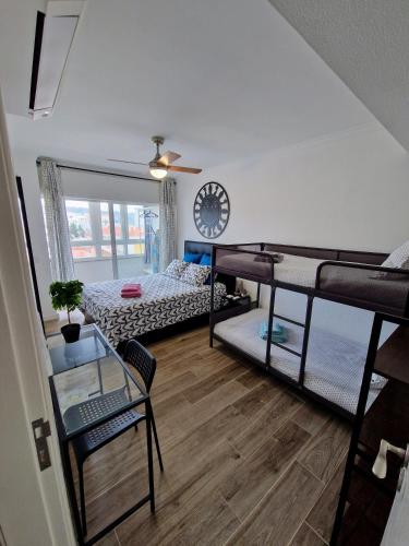 a dorm room with three bunk beds and a clock at Amazing Terrace Costa da Caparica in Costa da Caparica