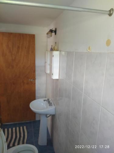 y baño con lavabo y aseo. en Departamento CatyDay en Mina Clavero