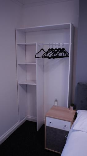 a bedroom with a bed and a closet with shelves at Reach Guest House in Birmingham