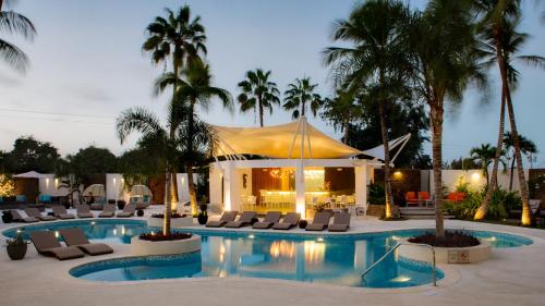 a resort pool with lounge chairs and a tent at H2otel By LD Hotel Boutique in La Mira