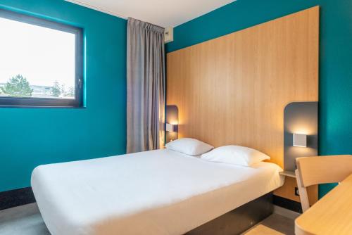 a hotel room with a bed and a window at B&B HOTEL Cholet Sud in Cholet