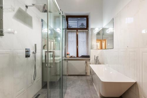 ein Bad mit einem Waschbecken und einer Glasdusche in der Unterkunft Luxury Apartment With Balcony next to the New York Café in Budapest
