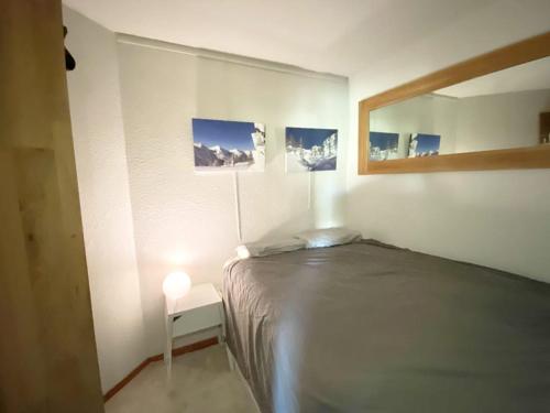 1 dormitorio con cama, espejo y lámpara en Exclusivité, 6Pers, Sauna, wifi, local à ski, en Isola 2000