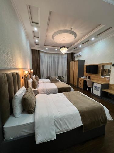 杜尚別的住宿－Hotel Sharq，酒店客房设有三张床和一张书桌