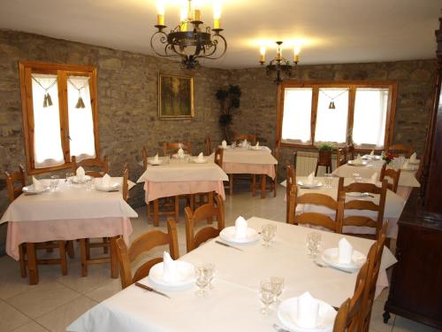 un restaurante con mesas y sillas blancas y ventanas en Casa Piquero en Sieste