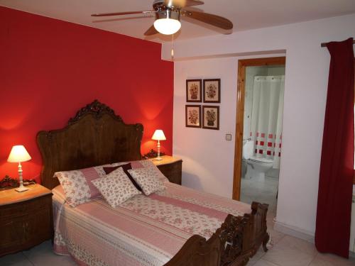 a bedroom with a bed and a red wall at Casa Piquero in Sieste