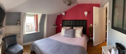 a bedroom with a bed with a red wall at Chambres d'Hôtes Au coin du spa in Boulogne-sur-Mer