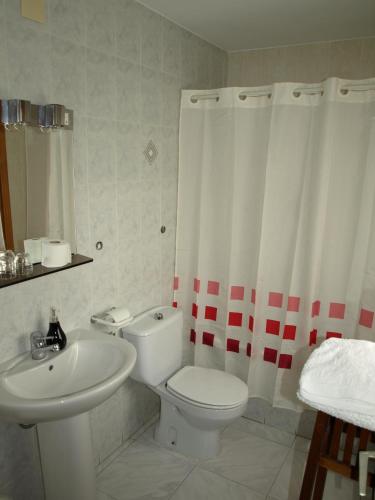 a bathroom with a white toilet and a sink at Casa Piquero in Sieste