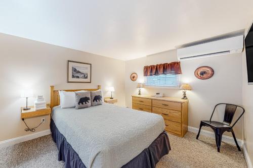 a bedroom with a bed and a desk and a chair at Northwoods Lodge Cabin 1 in Morrisville
