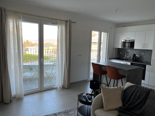 Il comprend un salon avec une table et une cuisine avec un balcon. dans l'établissement LE PARADIS BLANC, à Annecy