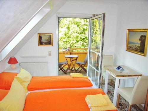 sypialnia z pomarańczowym łóżkiem i stołem w obiekcie Ostsee Hotel-Pension An der Lindenallee w mieście Bad Doberan