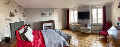 1 dormitorio con cama roja y chimenea en Au coin du spa, en Boulogne-sur-Mer