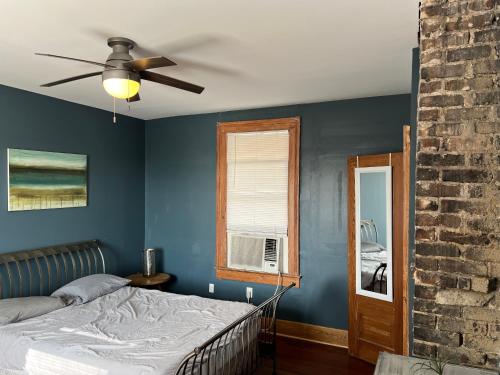 a blue bedroom with a bed and a ceiling fan at Uptown Treehouse in New Orleans