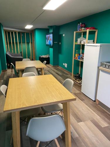 a classroom with tables and chairs and a green wall at Andaina in Sarria