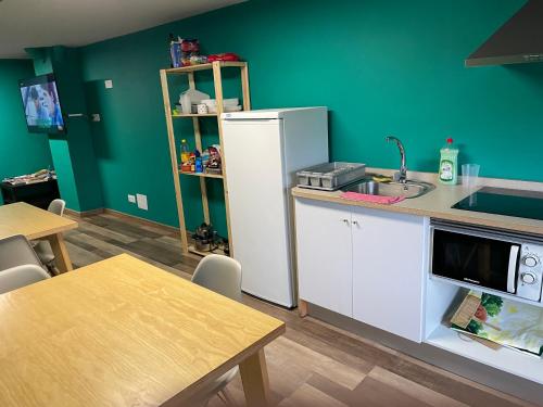 a kitchen with a white refrigerator and a table at Andaina in Sarria