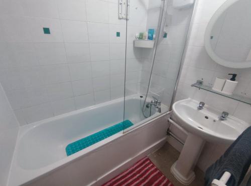 a bathroom with a tub and a sink and a shower at 2 BEDROOM FLAT NEXT TO ARSENAL STADIUM - HIGHBURY in London