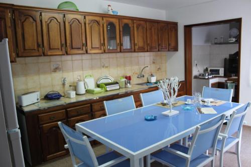 a kitchen with a blue table and blue chairs at Bella Italia Bem Estar Dona Adelina in Ponta Garça