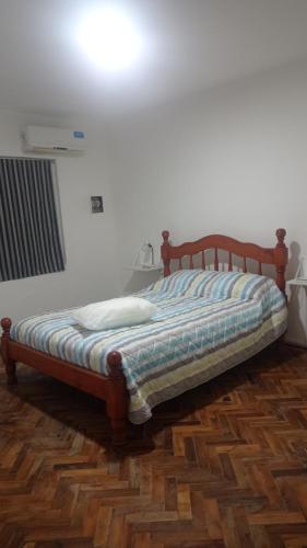 1 cama con marco de madera en una habitación en Casa Facu en Godoy Cruz