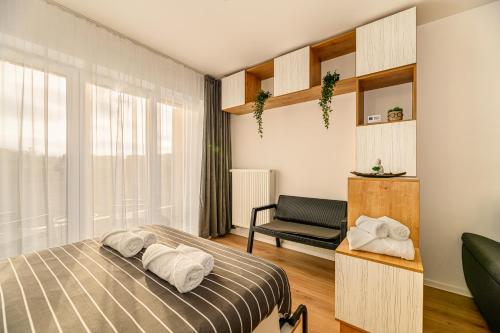 a bedroom with a bed and a chair at Luxury Landing Apartments Complex Qualis Brasov in Braşov