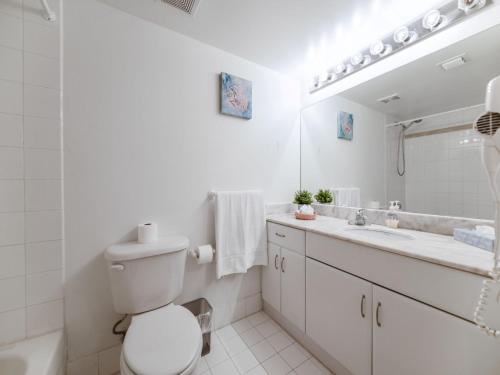 La salle de bains est pourvue de toilettes, d'un lavabo et d'un miroir. dans l'établissement Cozy and Bohemian Studio in Brickell, à Miami