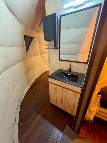 La salle de bains est pourvue d'un lavabo et d'un miroir dans une tente. dans l'établissement La bulle des coucous, à Saint-Hilaire-de-Riez