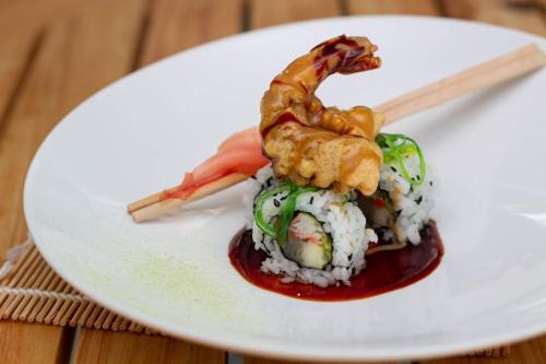 a white plate with food on top of rice and chopsticks at H2otel By LD Hotel Boutique in La Mira
