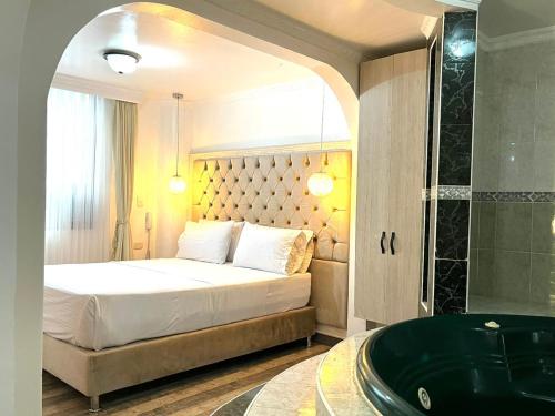 a bedroom with a bed and a tub in a room at Lavid Hotel Kennedy in Bogotá