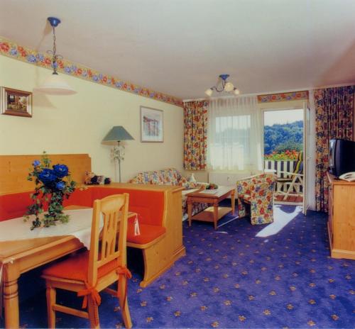 a living room with a couch and a table and chairs at Seehotel Zur Hopfenkönigin in Spalt