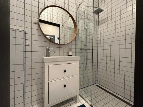 Baño de azulejos blancos con lavabo y espejo en The View and Design Studio, en Zagreb