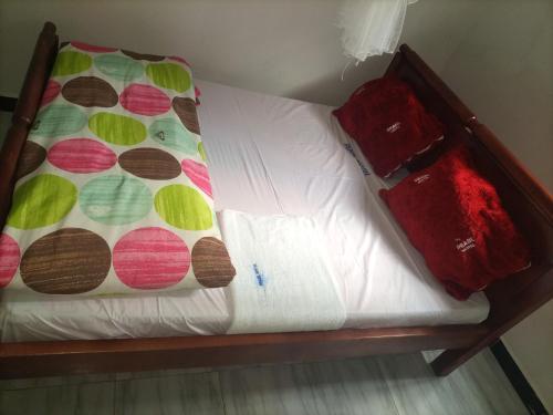 a bed with white sheets and a blanket on it at Pearl Furnished Rooms Buloba in Kampala