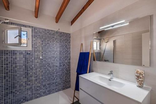 ein Bad mit einem Waschbecken und einem Spiegel in der Unterkunft Villa Sol del Sur 15 in Son Xoriguer