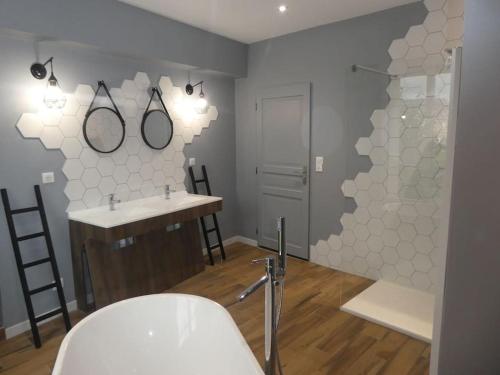 ein Badezimmer mit einem Waschbecken und zwei Spiegeln an der Wand in der Unterkunft Le gîte de l'écluse in Marolles-sous-Lignières