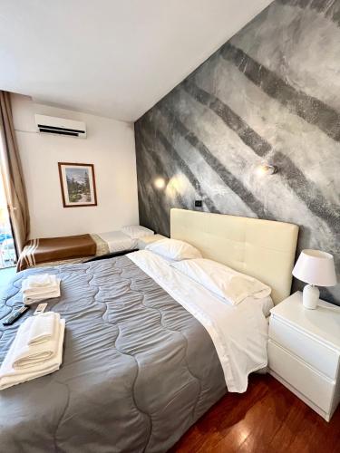 a bedroom with a large bed with a painting on the wall at Hotel Como in Siracusa