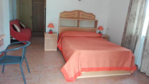 a bedroom with a red bed and a chair at Dodo Villa in Pointe aux Biches