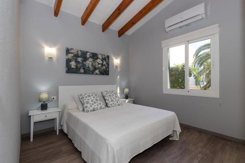 a white bedroom with a bed and a window at Casa Sol del Sur 4 in Son Xoriguer