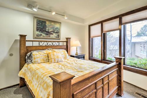 1 dormitorio con cama de madera y ventanas en Cottonwood Heights Home with Deck!, en Cottonwood Heights