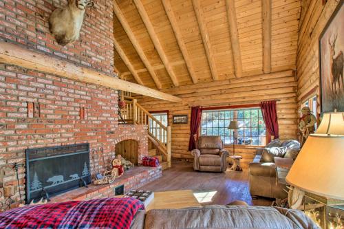 a living room with a brick wall and a fireplace at Pine Mountain Club Log Home with Deck and Grill! in Pine Mountain Club