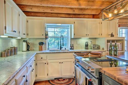 a kitchen with white cabinets and a sink at Pine Mountain Club Log Home with Deck and Grill! in Pine Mountain Club