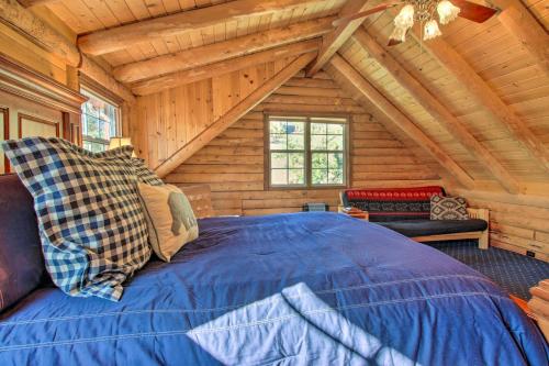 a bedroom with a large blue bed in a log cabin at Pine Mountain Club Log Home with Deck and Grill! in Pine Mountain Club