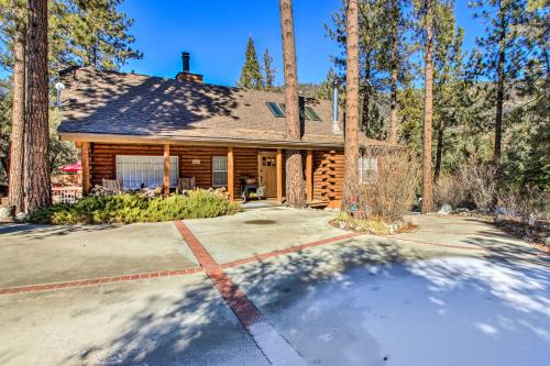 a log house with a driveway in front of it at Pine Mountain Club Log Home with Deck and Grill! in Pine Mountain Club