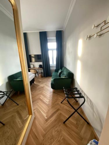 a living room with a green couch and a mirror at Boutique Hotel Kolbeck in Vienna
