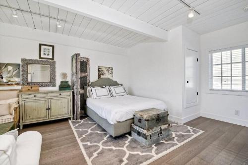 Un dormitorio blanco con una cama y un espejo. en Ocean View From Private Patio, Across Street From Beach, en Carlsbad