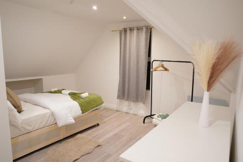 a white bedroom with a bed and a window at Peaceful Luxury Apartment in Croydon