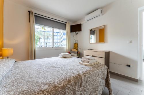 een slaapkamer met een bed en een raam bij Steps from Puerto Marina in Benalmádena