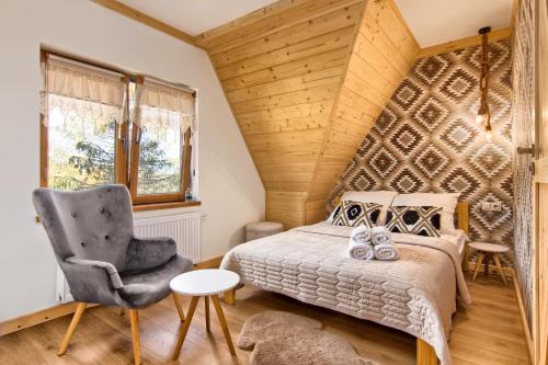 um quarto com uma cama e uma cadeira em Apartamenty Kucovka 11 em Brzegi