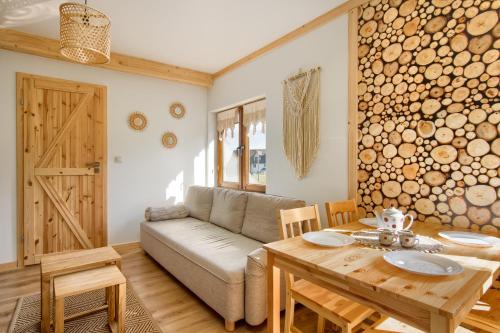een woonkamer met een bank en een houten tafel bij Apartamenty Kucovka 11 in Brzegi