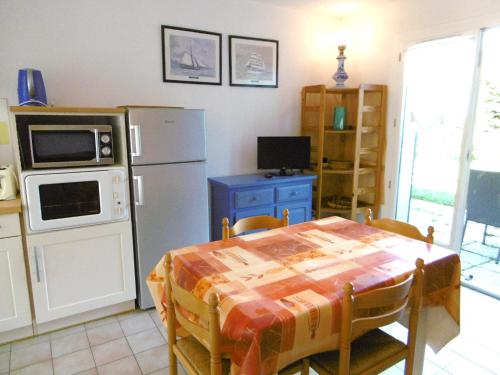 La cuisine est équipée d'une table, d'un four micro-ondes et d'un réfrigérateur. dans l'établissement Maisonnette Kristell, à Sarzeau