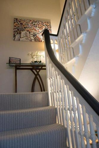 a stairway with white stairs and a painting on the wall at Rooftops in Louth