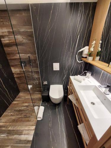 a bathroom with a white toilet and a sink at Lipa Hotel in Travnik