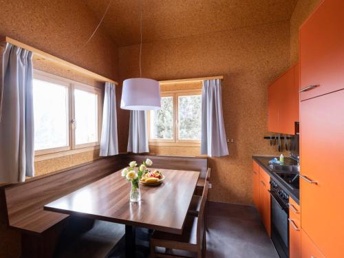 a kitchen with a wooden table with a vase of flowers on it at Holiday Home Maiensäss Komfort by Interhome in Urmein